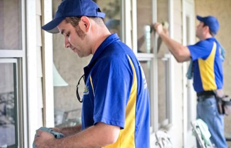 gleam team team members performing window cleaning services on the windows of a home