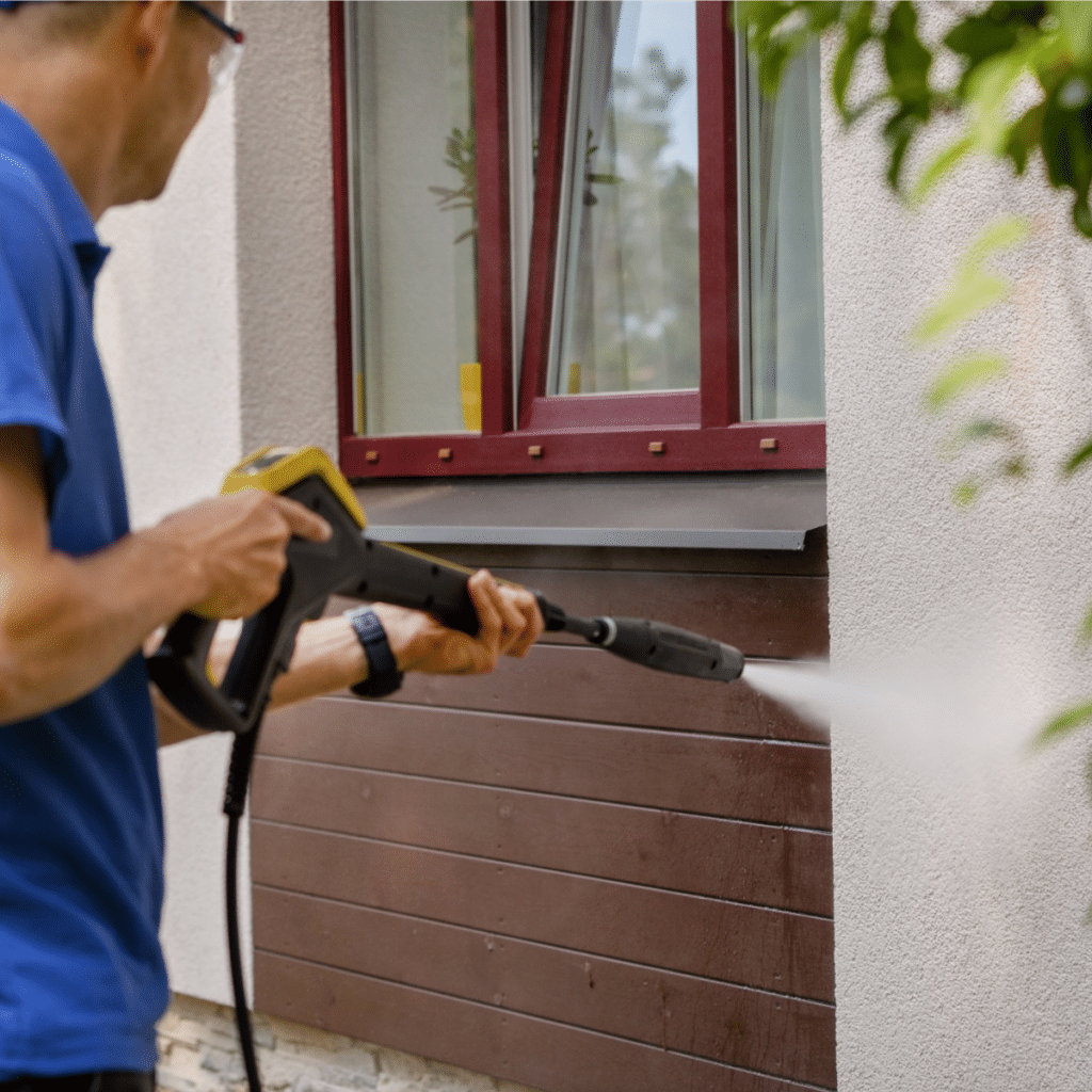 man power washing the exterior of house