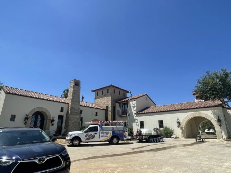 gleam team exterior cleaning performing house washing services on a large home in san antonio