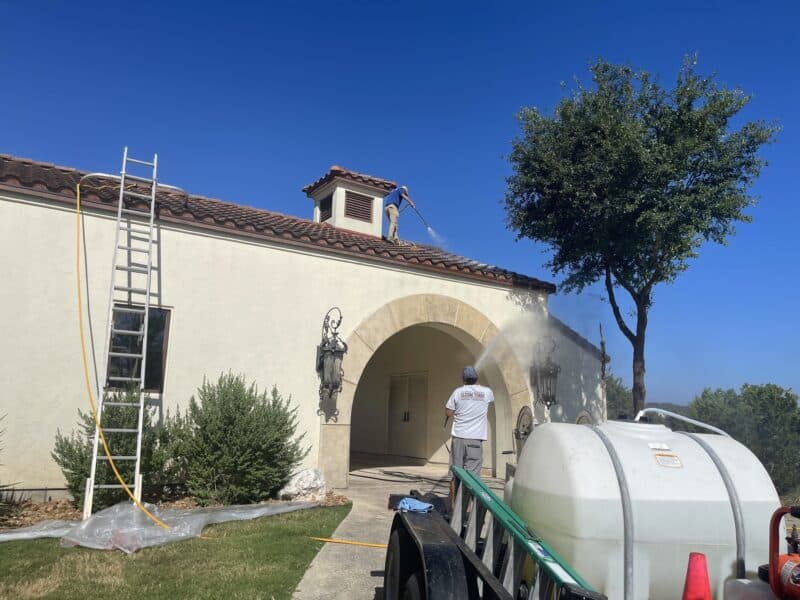 gleam team members performing house washing on a san antonio home